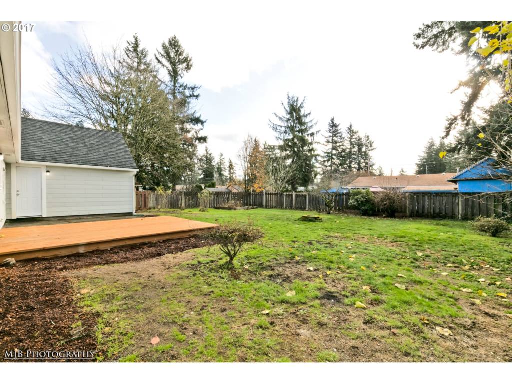 large fenced yard with patio and wood deck